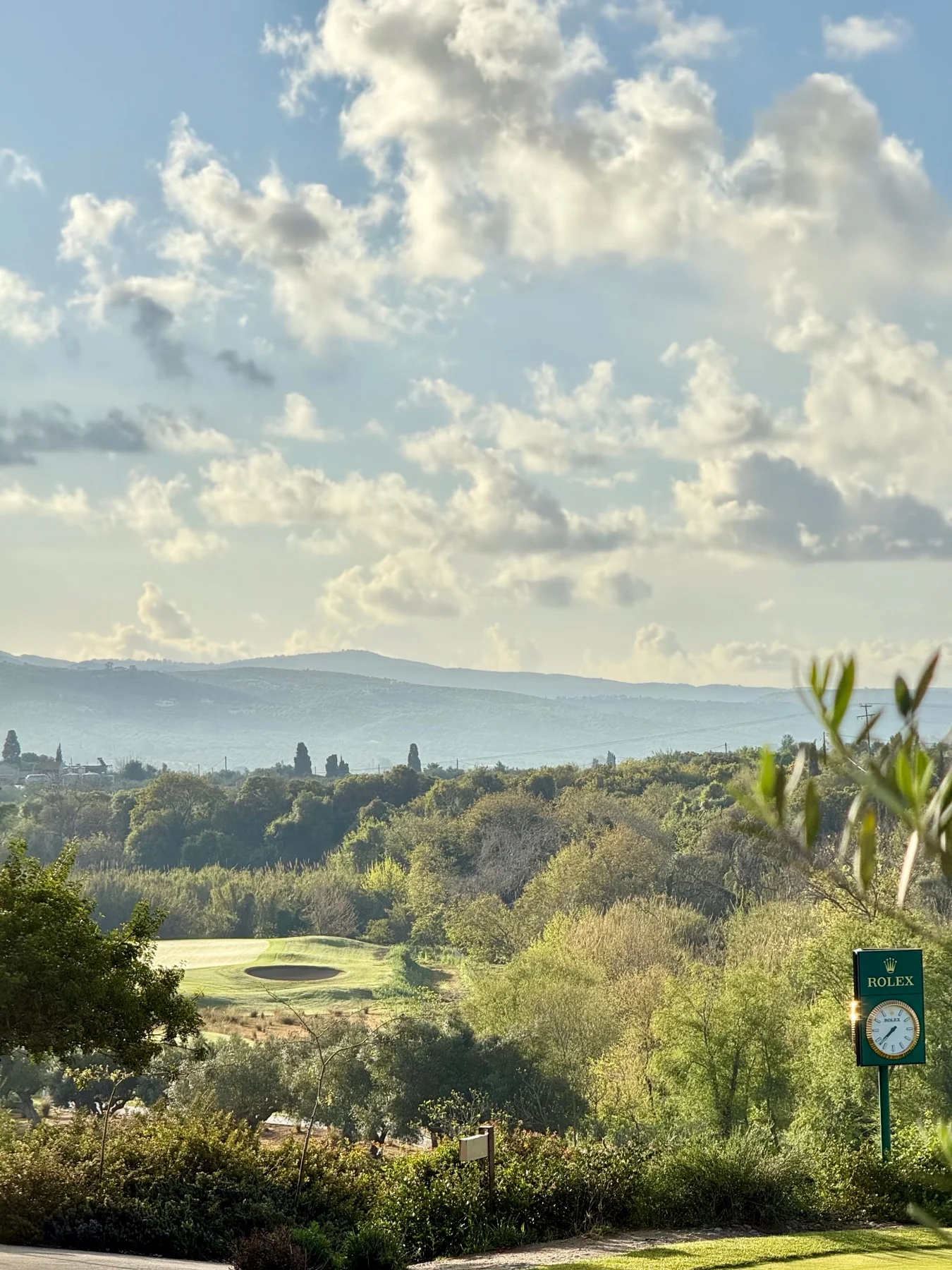 Golfplatz zwischen Bäumen und Hügeln